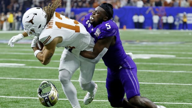 UW linebacker Edefuan Ulofoshio loses his helmet ase brings down Jordan Whittingham.